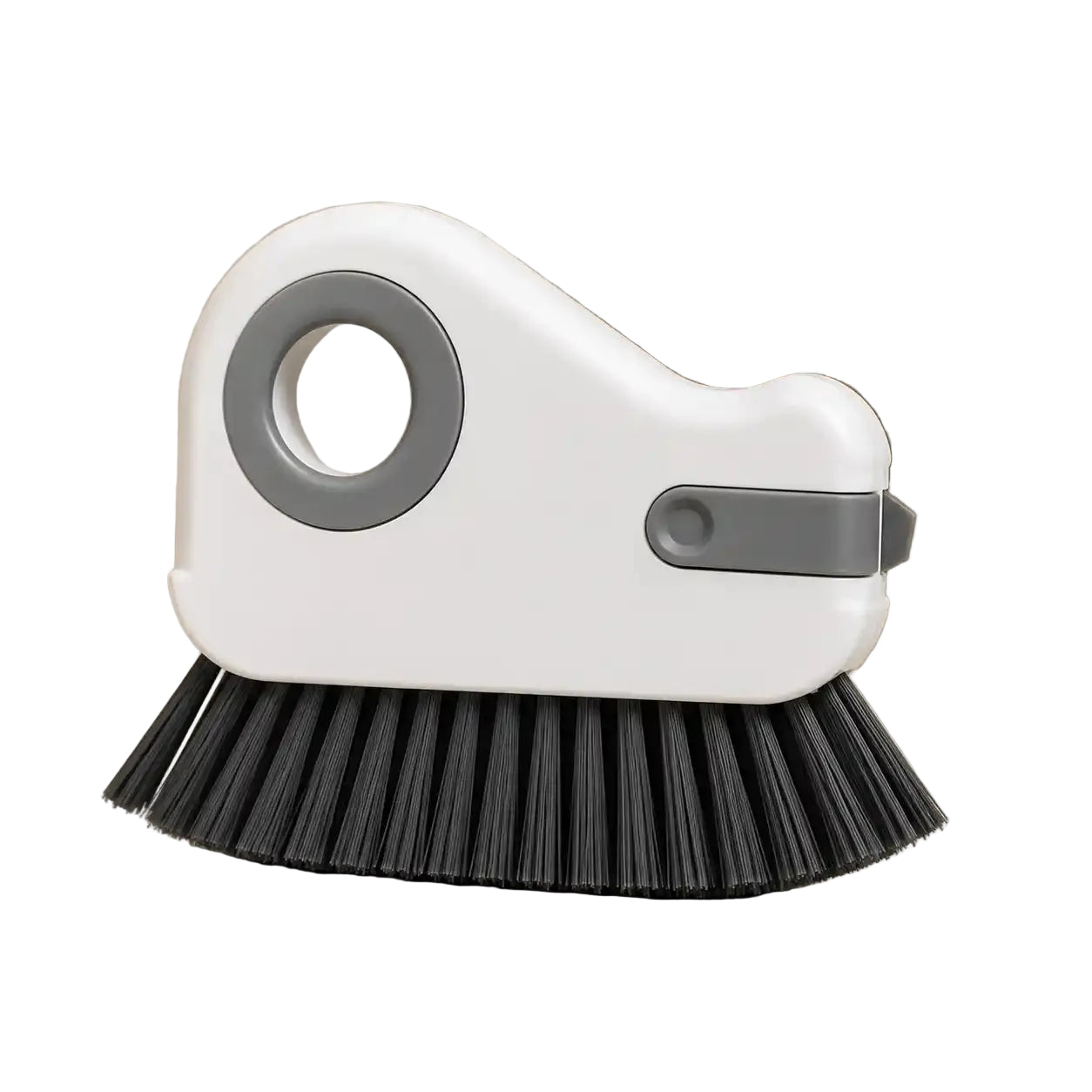 Gray variant handheld groove cleaning brush with a white body, gray grip ring, integrated gray scraper, and dense black bristles, displayed on a warm neutral background for cleaning window tracks, sliding door rails, grout lines, and narrow household gaps.