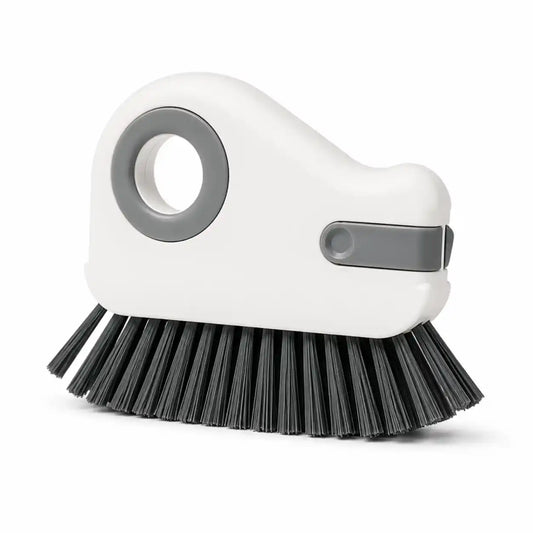 White handheld groove cleaning brush with dense black bristles and an integrated scraper, designed for cleaning window tracks, sliding door rails, tile grout, and narrow household gaps.