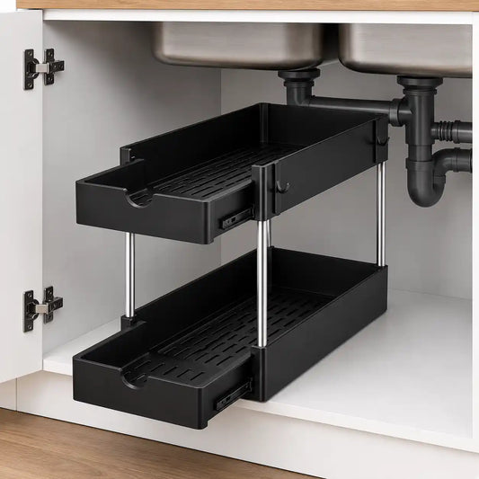 Black 2-tier under sink storage organizer shelf with sliding drawers installed inside a modern white kitchen cabinet beneath the sink, featuring silver support rods and pull-out baskets for organized household storage.